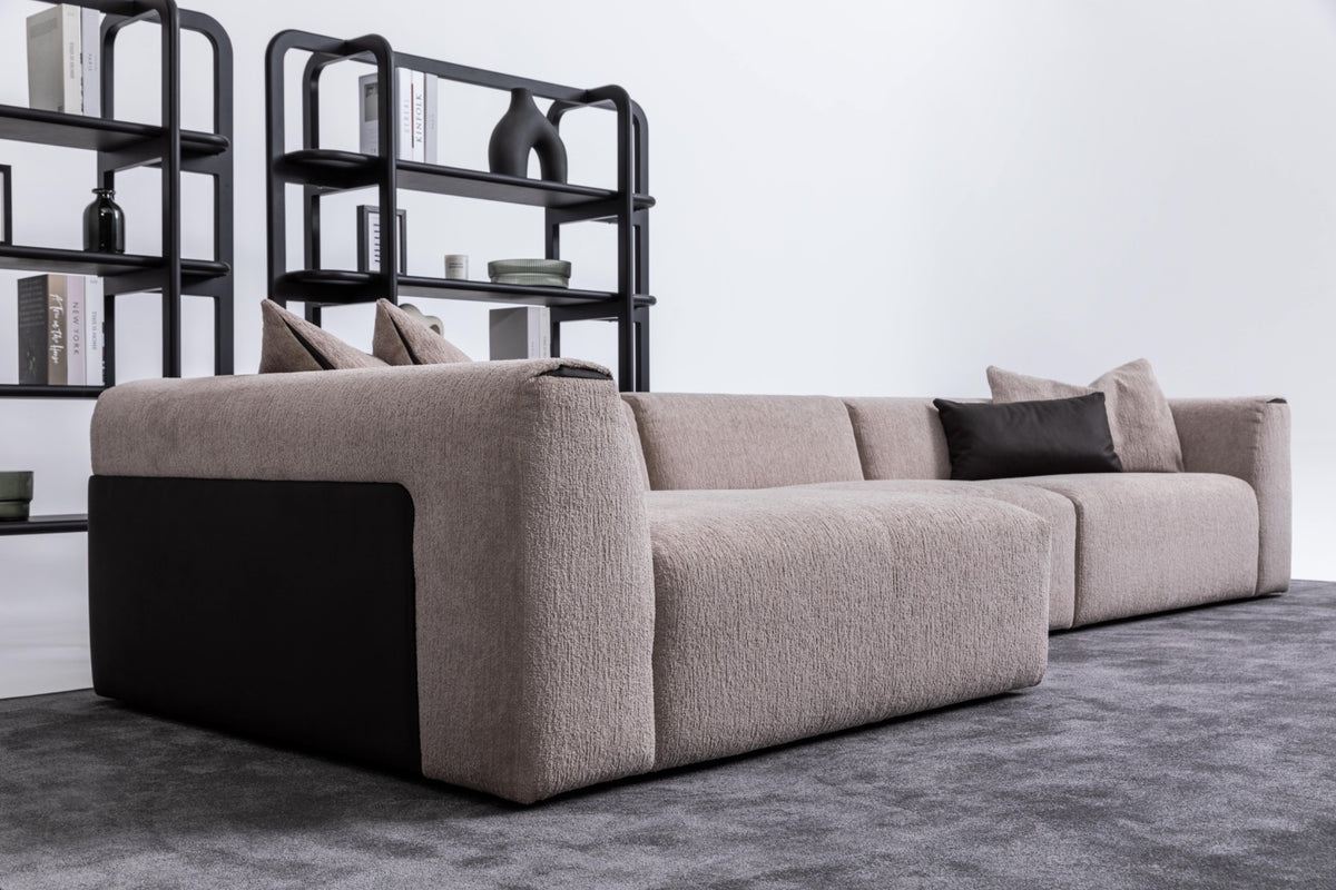 Soho luxury left chaise modular corner sofa viewed from rear three-quarter angle showing low profile and black contrasting side detailing