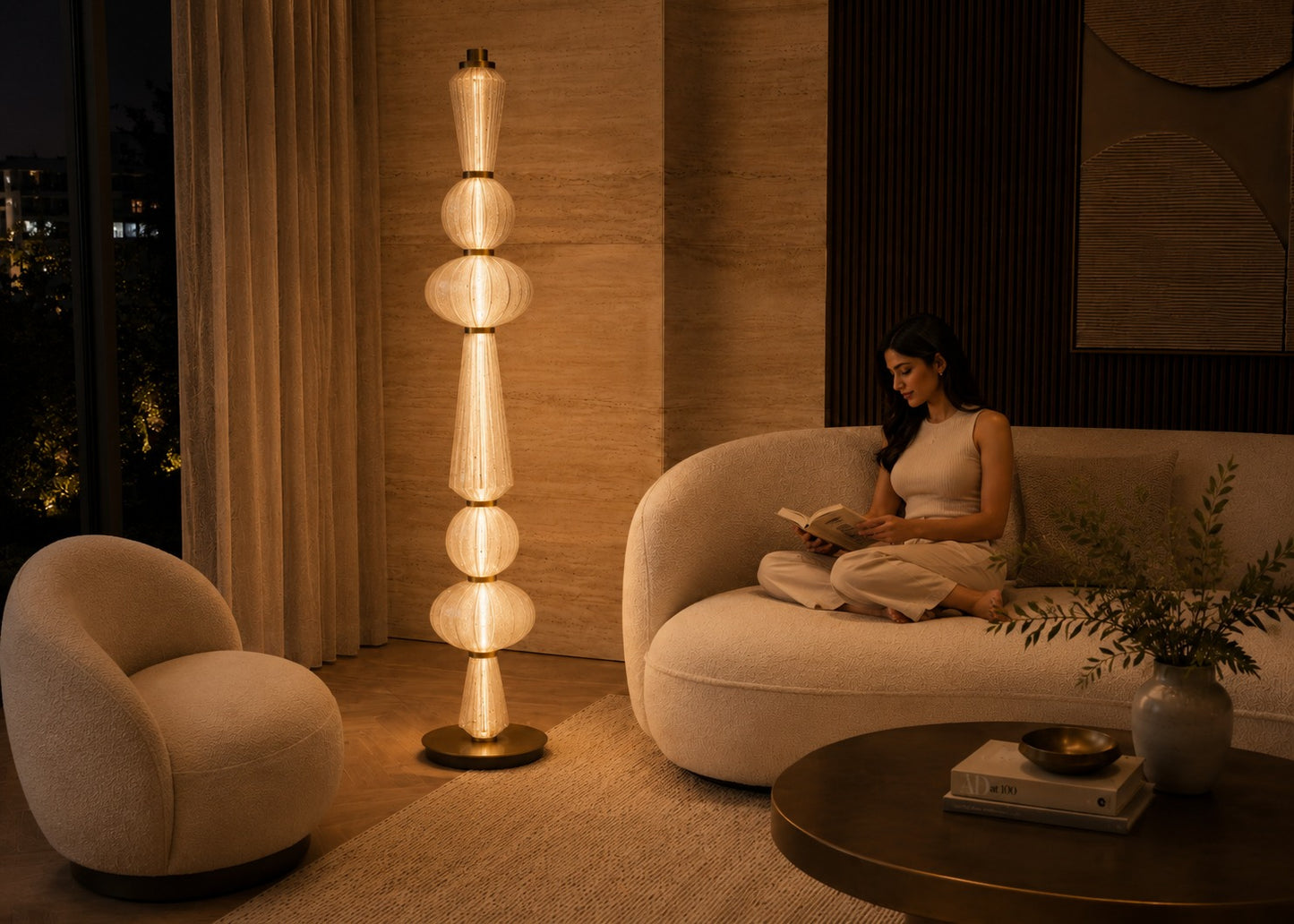 Woman reading a book on a couch in a modern living room with a tall floor lamp.