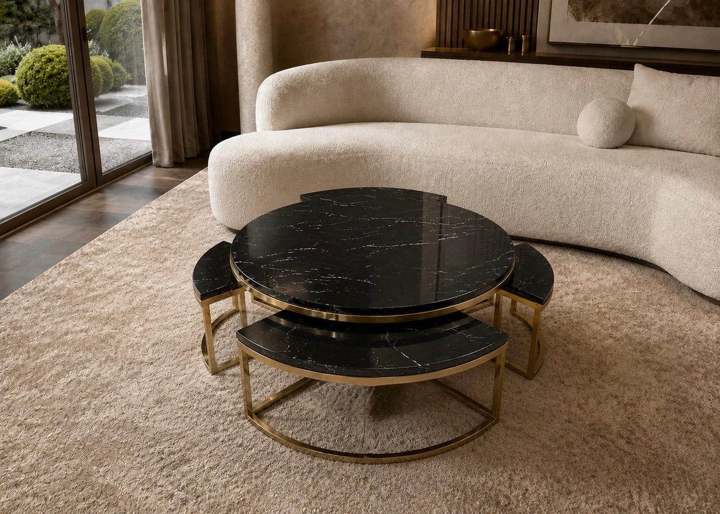 Round marble coffee table with gold base in a living room setting
