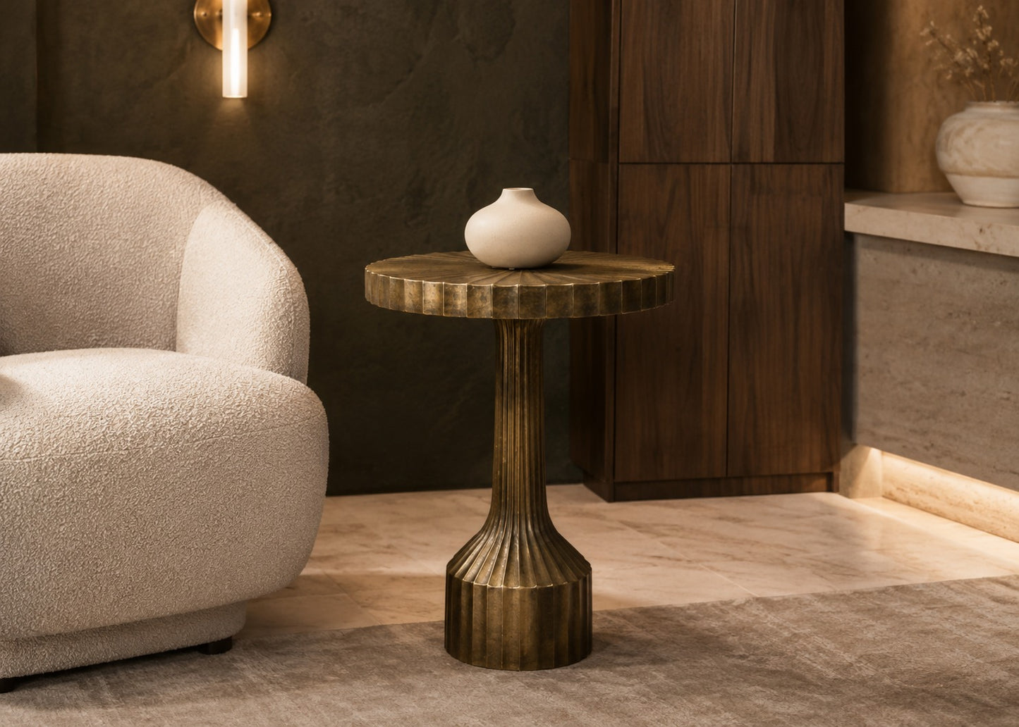 Decorative table with a vase next to a textured armchair in a room with wooden paneling.