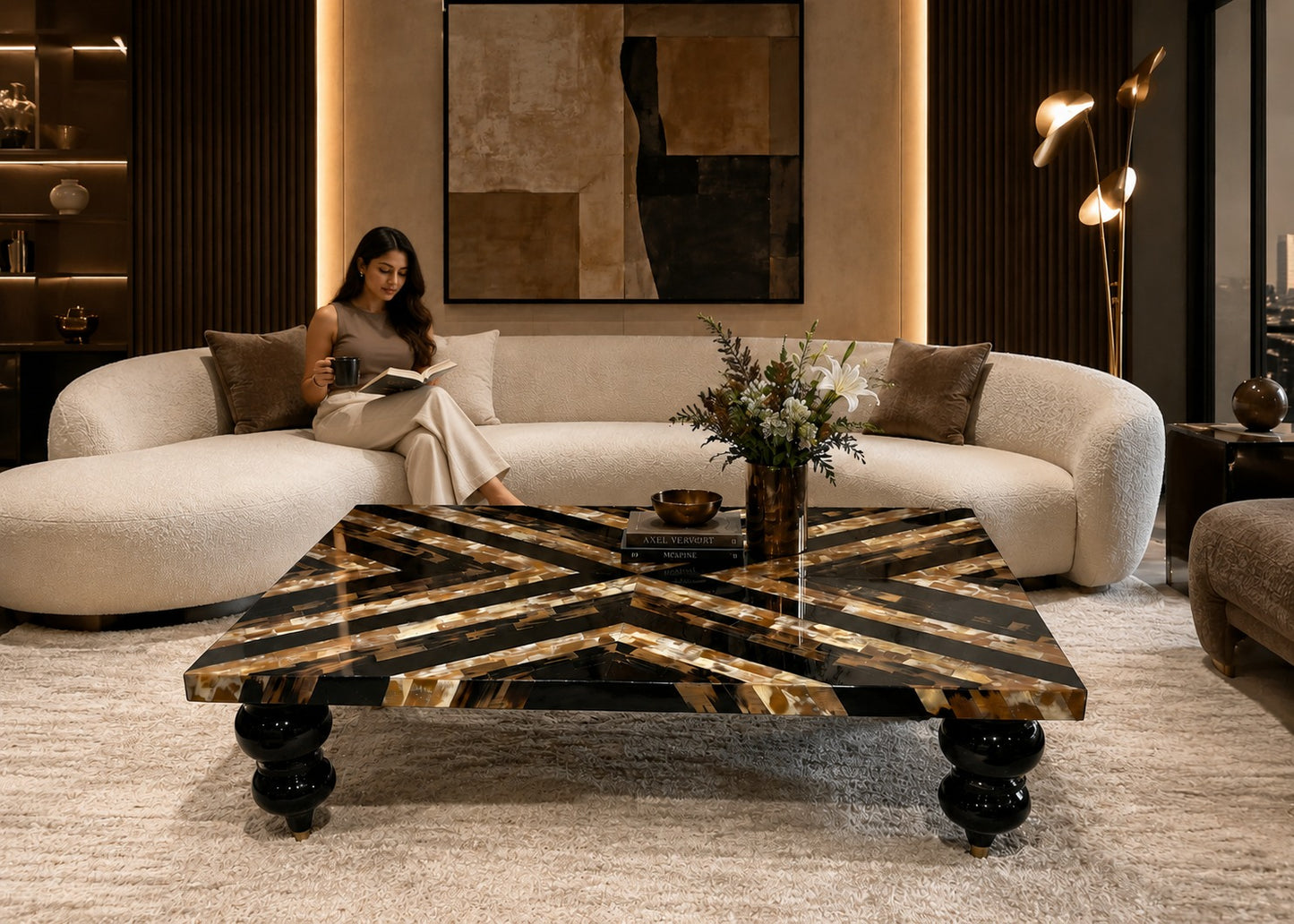 Woman reading a book on a white sofa in a stylish living room with a decorative coffee table.