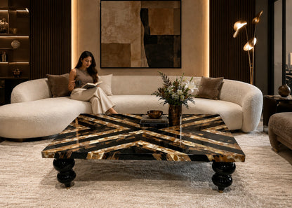 Woman reading a book on a white sofa in a stylish living room with a decorative coffee table.