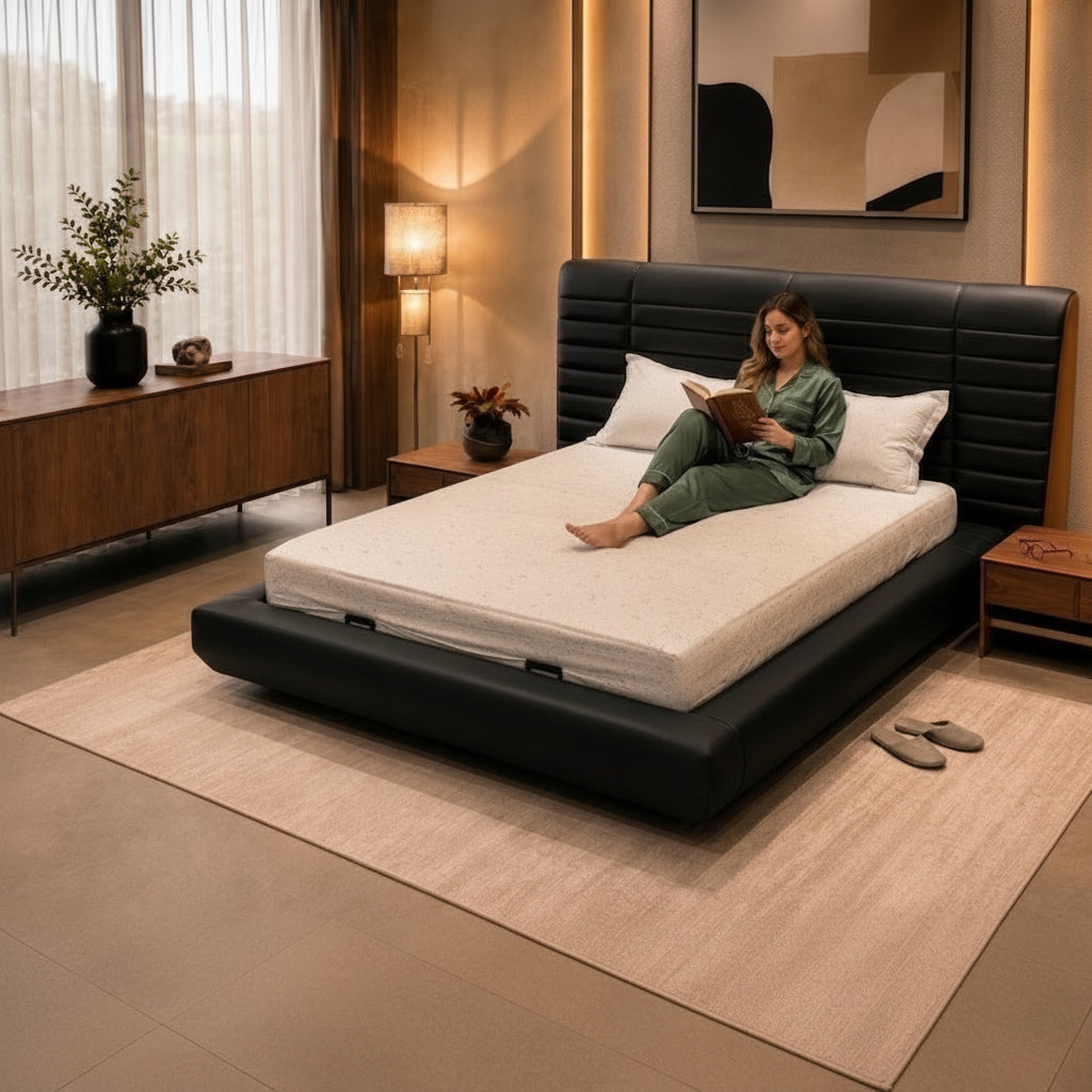 Woman sitting on a bed in a modern bedroom reading a book.