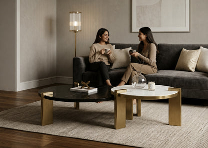 Two women sitting on a couch in a modern living room with coffee tables.