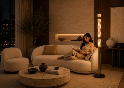 Woman reading a book on a couch in a dimly lit living room.