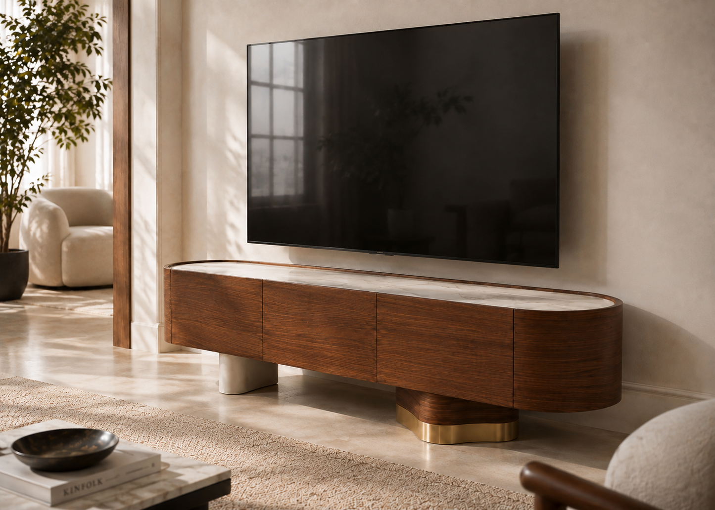 A modern curved wooden TV stand with a white marble top and gold geometric base, supporting a large black flat-screen TV against a beige wall in a styled living room.