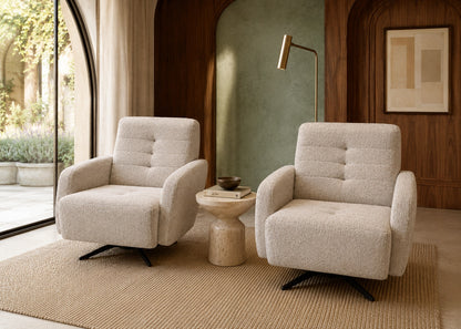 Two beige armchairs in a modern living room with a side table and lamp.
