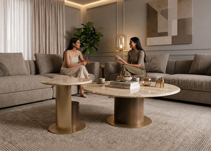 Two women sitting on a couch in a modern living room with a coffee table and decorative items.