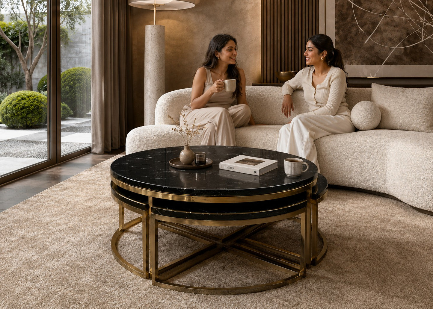 Two women sitting on a couch in a modern living room with a coffee table.