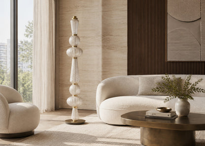Modern living room with a white sofa, armchair, and decorative floor lamp.