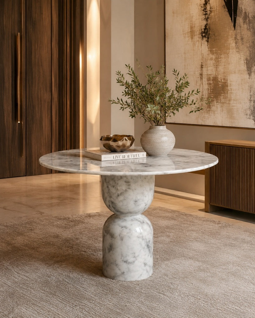 Marble side table with a vase and books in a room with wooden walls and a painting.