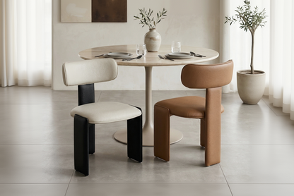 Dining area with a round table and two chairs in a modern interior setting.