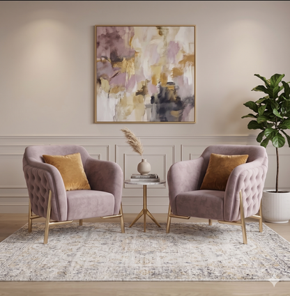 Two pink armchairs with gold legs in a living room setting with a abstract painting on the wall.