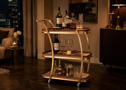 Bar cart with wine bottles and glasses in a dimly lit room