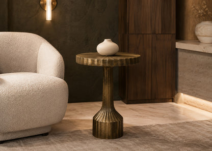 Decorative table with a vase next to a textured armchair in a room with wooden paneling.