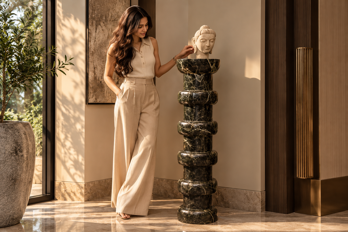 Full-length human figure beside Noir Ritmo tall dark green-black marble pedestal, showing scale and elegant entrance styling