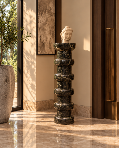 Noir Ritmo tall stacked-ring marble pedestal and white stone bust in sunlit modern foyer without any people