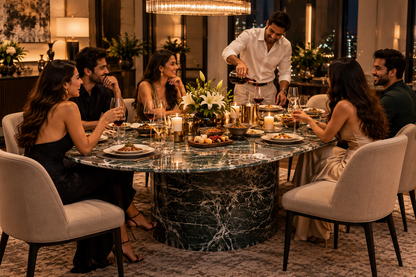 Six guests enjoying a lively dinner party around sculptural dark green veined marble oval dining table in a contemporary luxury home