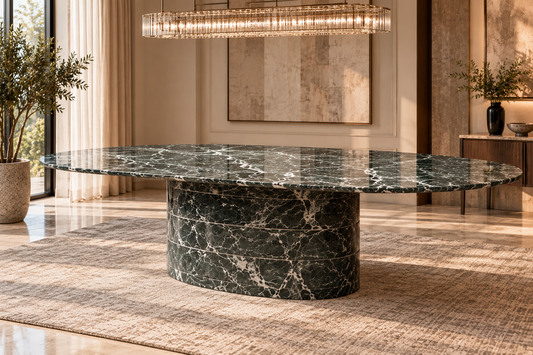 Verde Solenne oval green-black marble dining table with broad rounded sculptural pedestal on beige carpet in elegant formal daytime dining room