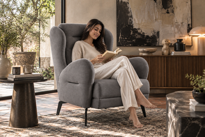 Barcelona Armchair in grey upholstery with a modern Indian woman reading comfortably in a warm luxury interior
