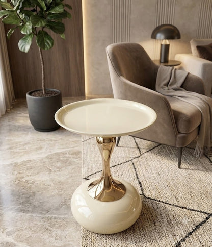 Modern side table with gold base and white top in a living room setting