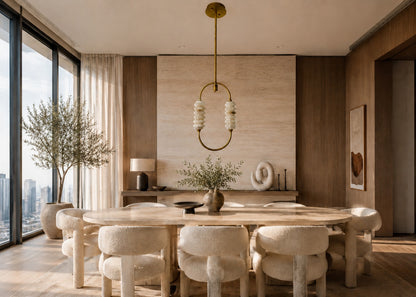 Modern dining room with a round table and chairs, large windows, and decorative elements.
