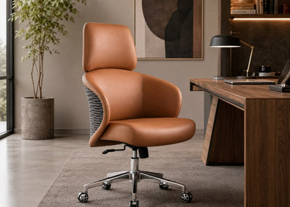 A modern tan leather office chair with a curved backrest and a gray textured side panel, positioned in a contemporary home office next to a wooden desk.