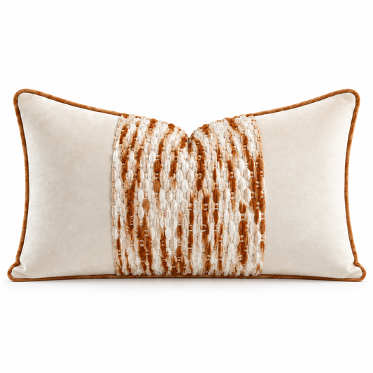 A rectangular lumbar throw pillow in cream velvet with a central vertical panel of textured woven stripes in brown and cream, finished with a warm brown piped edge.