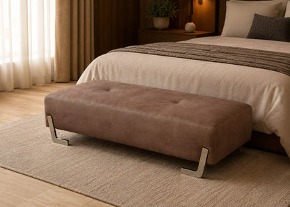 Brown ottoman in front of a bed in a bedroom setting