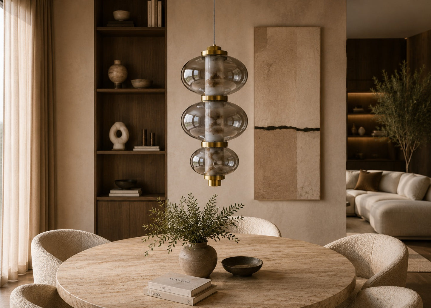 Modern living room with a round wooden table, pendant light, and bookshelf.