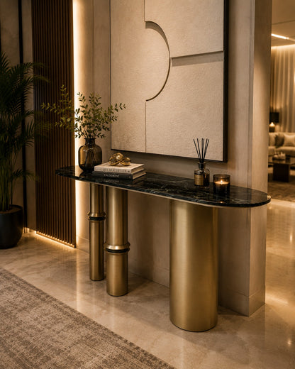Modern console table with marble top and gold legs in a stylish interior setting.