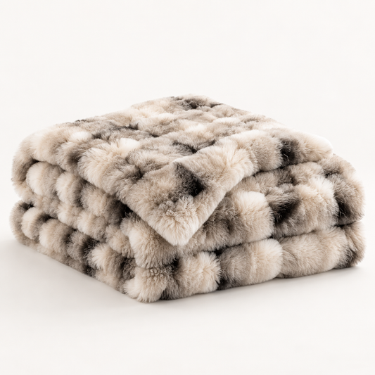 Eira Faux Fur Throw folded on a clean neutral background in ivory taupe grey and charcoal