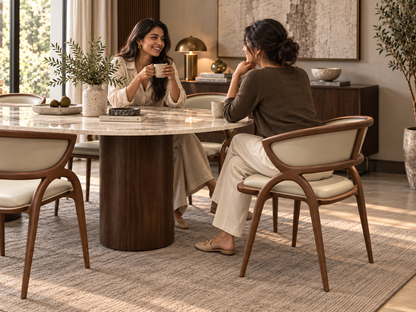 Elara Dining Chair in solid walnut wood and ivory vegan leather styled with two women in a luxury dining room
