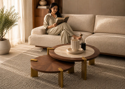 Woman reading a book on a beige sofa in a cozy living room with wooden coffee tables.