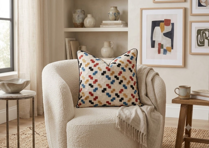 Mosaic Step Cushion in ivory with multicolour geometric woven motifs, styled on a cream armchair