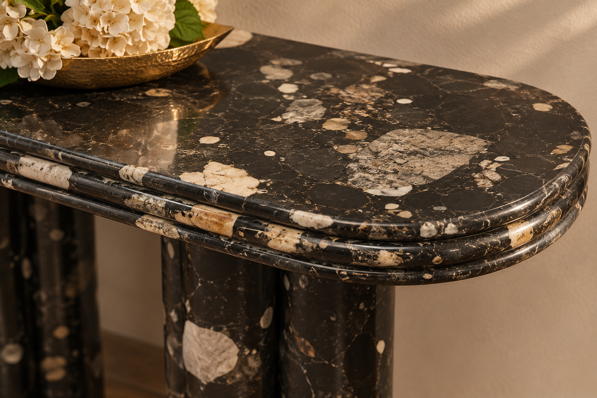 Cavaro marble console top close-up: polished black stone appearance with cream and grey mineral fragments and rounded layered edge