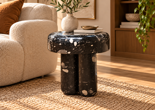 Noctis black terrazzo side table with level rounded top and twin cylindrical legs in elegant sunlit living room