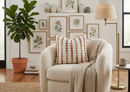 Terracotta Lane Cushion styled on a cream boucle armchair in a warm botanical living room