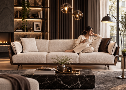 Woman enjoying coffee on Togo cream textured three-seater sofa with dark espresso leather wing panels